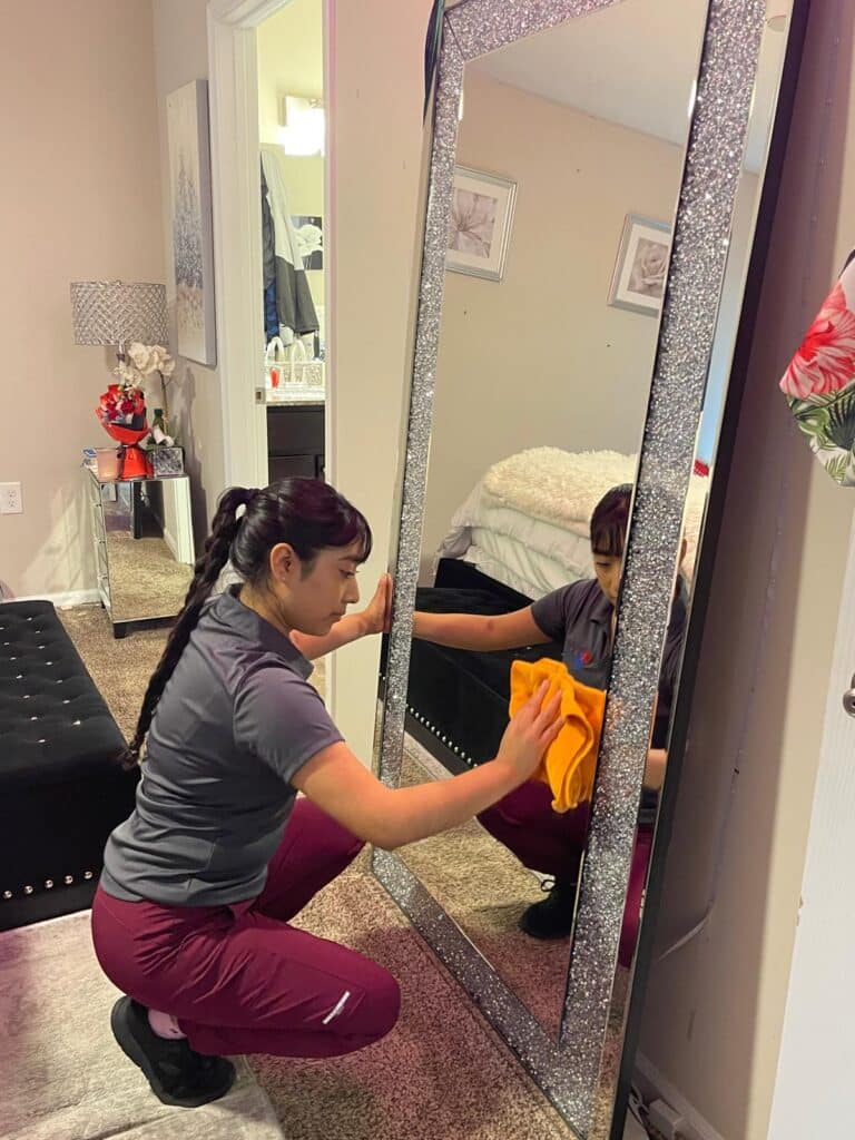 tessa cleaning worker cleaning mirror in bedroom